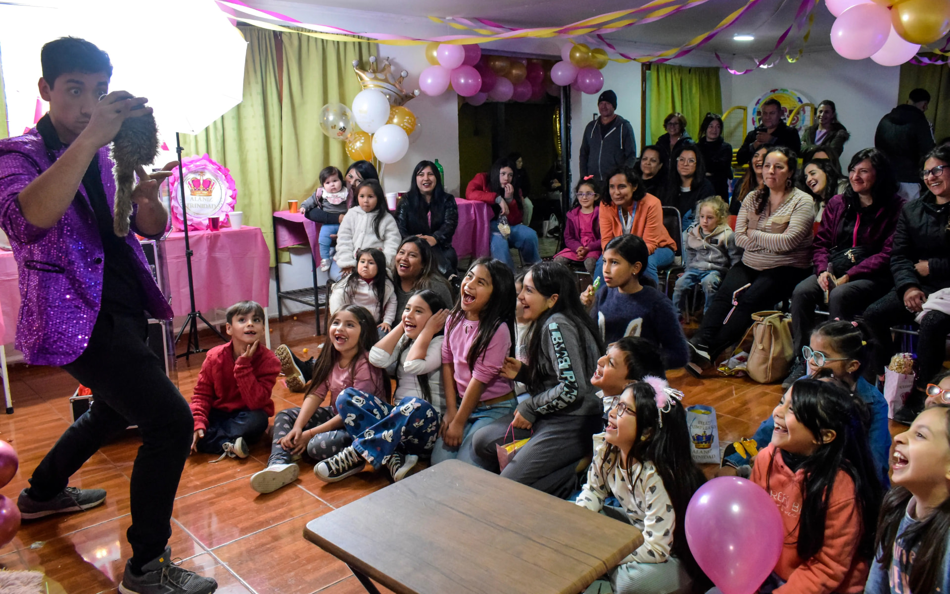 Aníbal con traje morado haciendo reír a niños y familias